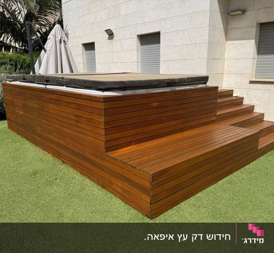 דק עץ ליד בריכה בחצר בית